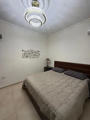 a bedroom with a large bed and a chandelier at Furnished luxuries Apartment with a Stunning View in Amman