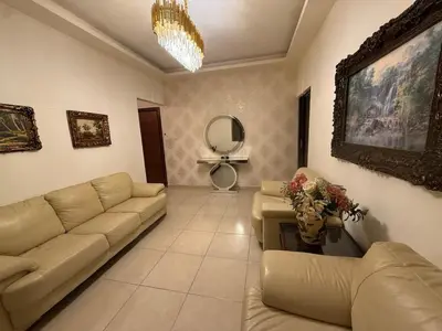 a living room with a couch and a table at Furnished luxuries Apartment with a Stunning View in Amman