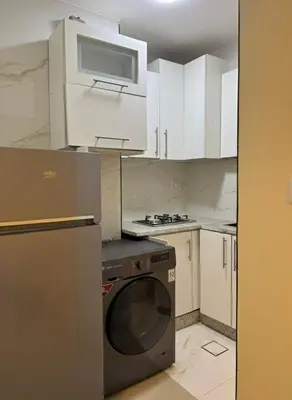 a kitchen with white cabinets and a microwave and a dishwasher at The cava in Amman