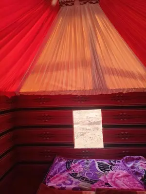 a bedroom with a red ceiling and a window at Ayed Wadi Rum camp in Wadi Rum