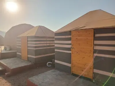 a group of three domes in the desert at Ayed Wadi Rum camp in Wadi Rum