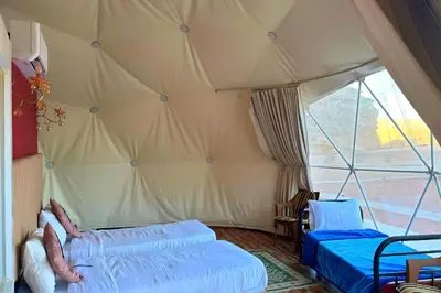 a bedroom with two beds in a tent at Desert Oasis in Wadi Rum Village - Cozy Lodge Room in Aqaba
