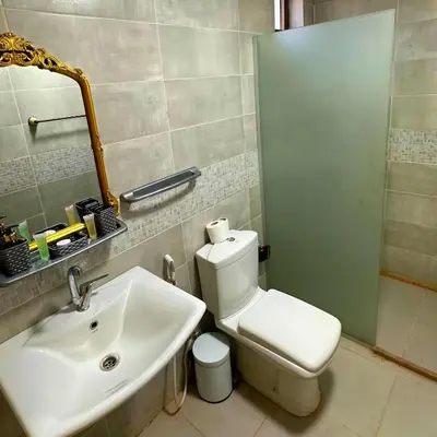 a bathroom with a white toilet and a sink at Desert Oasis in Wadi Rum Village - Cozy Lodge Room in Aqaba