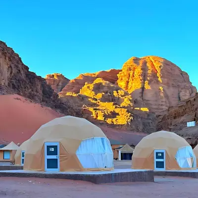 a group of tents in front of a mountain at Desert Oasis in Wadi Rum Village - Cozy Lodge Room in Aqaba