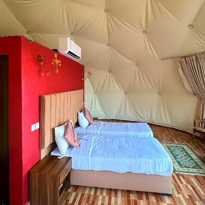 a bedroom with a bed in a tent at Desert Oasis in Wadi Rum Village - Cozy Lodge Room in Aqaba