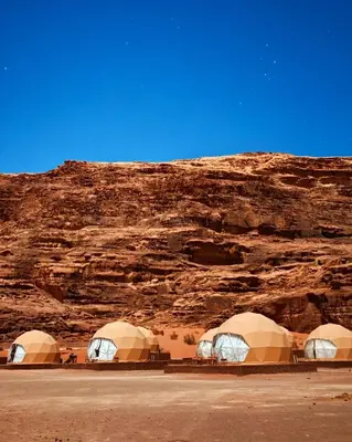 a group of three tents in the desert at Desert Oasis in Wadi Rum Village - Cozy Lodge Room in Aqaba