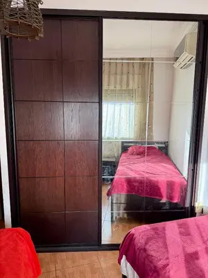 a bedroom with a mirrored closet with a bed in it at Fully Furnished apartment for rent in Amman Khalda in Amman