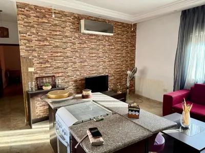 a living room with a brick wall at Fully Furnished apartment for rent in Amman Khalda in Amman