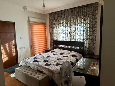 a bedroom with a bed and a chair in it at Fully Furnished apartment for rent in Amman Khalda in Amman