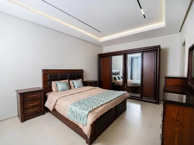 a bedroom with a bed and a dresser and a television at طريق المطار بوليفارد الامعري in Amman