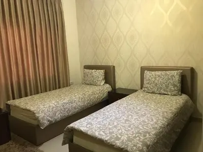 a room with two beds and a window with curtains at luxury apartment in amman, abdoun in Amman