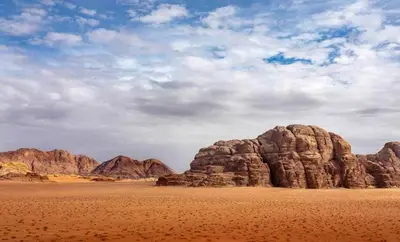 a view of the desert with mountains in the background at faisal wadi rum in Wadi Rum