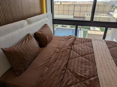 a bed with two pillows sitting in front of a window at Noorhan Private Luxury Layover Villa - 10 Minutes to Airport in Amman