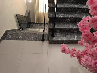 an image of stairs with pink flowers in the foreground at Noorhan Private Luxury Layover Villa - 10 Minutes to Airport in Amman