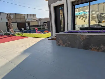 a patio with a swimming pool and a building at Noorhan Private Luxury Layover Villa - 10 Minutes to Airport in Amman