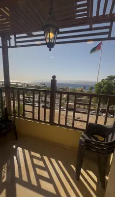 a balcony with a chair and a view of the ocean at السلام للشقق الفندقية peace hotel apartments in Aqaba