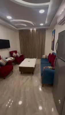 a living room with red chairs and a blue couch at السلام للشقق الفندقية peace hotel apartments in Aqaba