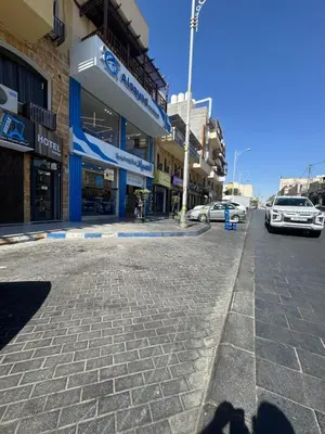 a street with cars parked in front of buildings at السلام للشقق الفندقية peace hotel apartments in Aqaba
