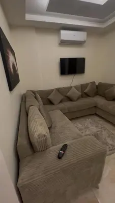 a living room with a couch with a remote control at السلام الشقق الفندقية peace hotel apartments in Aqaba