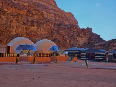 two domes in a desert with a mountain in the background at Lunar scape haven in Wadi Rum