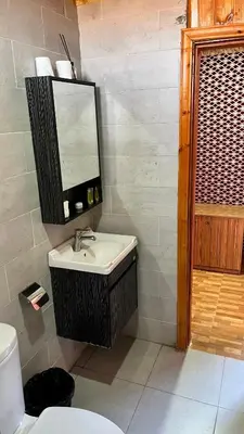 a bathroom with a sink and a mirror and a toilet at Wadi Rum Sila Camp in Wadi Rum