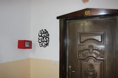 a door with a clock on the wall next to it at Premium apartment Section A in Wadi Musa