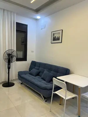 a living room with a blue couch and a table at Nice place in Irbid
