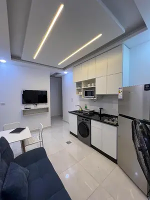 a kitchen and living room with a couch and a table at Nice place in Irbid
