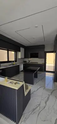 a large kitchen with a white ceiling and marble floors at شاليه المهرة in Murayjimat Ibn Ḩāmid
