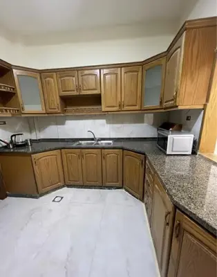 an empty kitchen with wooden cabinets and a microwave at Miami Luxe Apartment ماركا