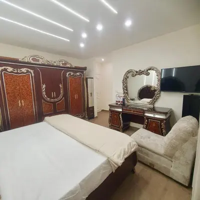a bedroom with a bed and a chair and a mirror at Cozy 3BR Apartment by 7th Circle in Amman