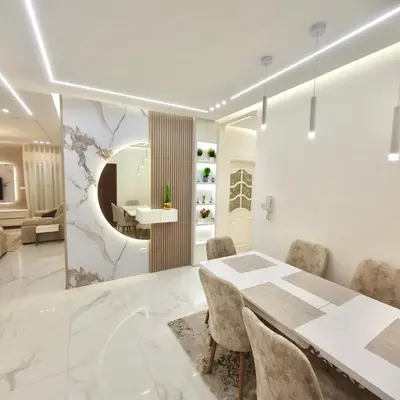 a white dining room with a table and chairs at Cozy 3BR Apartment by 7th Circle in Amman
