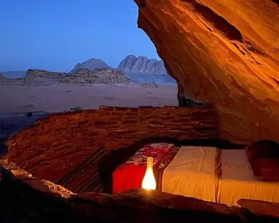 a bedroom with a bed in the desert at Nomad Heights Authentic Bedouin Cave Experience in Wadi Rum in Wadi Rum