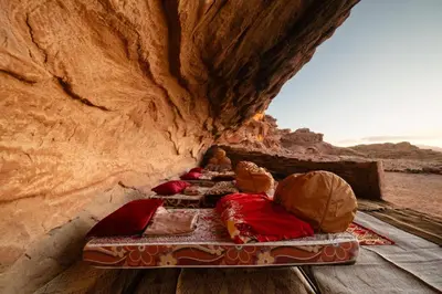 a group of beds in a cave in the desert at Nomad Heights Authentic Bedouin Cave Experience in Wadi Rum in Wadi Rum