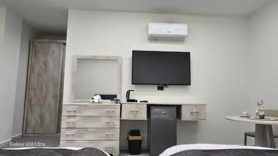 a living room with a tv on a wall at Jeeso Hotel in Jerash