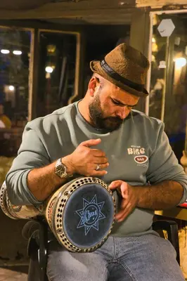 a man sitting in a chair holding a plate at TOWER Hotel in Dana