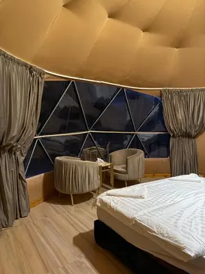 a bedroom with a bed and a large window at Eileen wadi rum camp in Wadi Rum