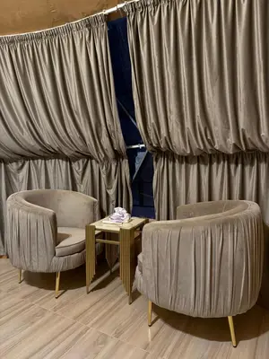 two chairs and a table in front of curtains at Eileen wadi rum camp in Wadi Rum