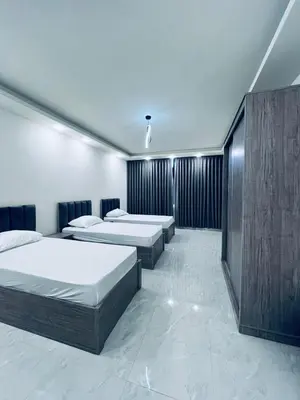 a room with four beds in a room with at Zurich Furnished Apartments in Al Mafraq