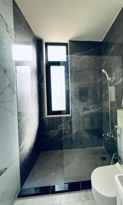 a bathroom with a shower and a toilet and a sink at Zurich Furnished Apartments in Al Mafraq