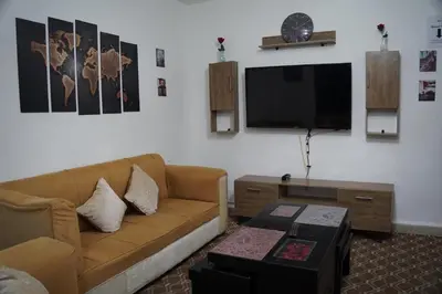 a living room with a couch and a flat screen tv at Petra entrance Apartment in Petra