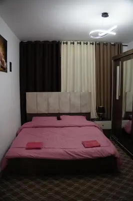 a bedroom with a large bed with a red blanket at Petra entrance Apartment in Petra