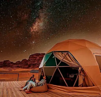 a couple of people sitting in front of a tent at Gmal Rum Cano in Wadi Rum