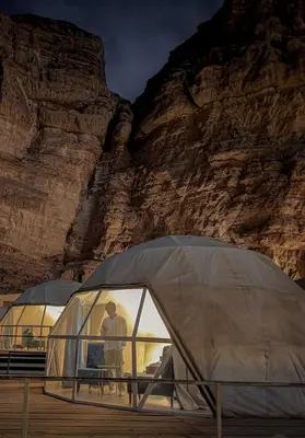 a man standing in a tent in front of a mountain at Gmal Rum Cano in Wadi Rum