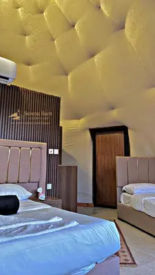 a bedroom with two beds and a ceiling at Sana Rum Luxury Camp in Wadi Rum