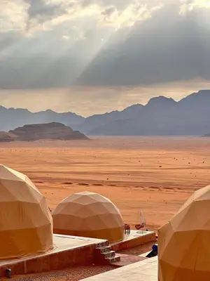 two domes in the desert with mountains in the background at Sana Rum Luxury Camp in Wadi Rum