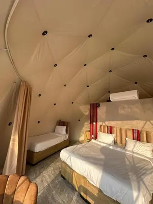 a room with two beds in a tent at Sana Rum Luxury Camp in Wadi Rum