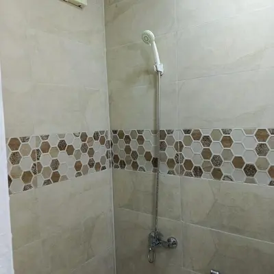 a bathroom with a shower with a glass door at ابو عبدالله للشقق الفندقيه in Ajloun