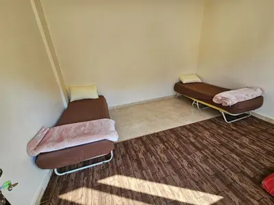a room with two beds and a rug at Rum Adventures Hostel in Wadi Rum