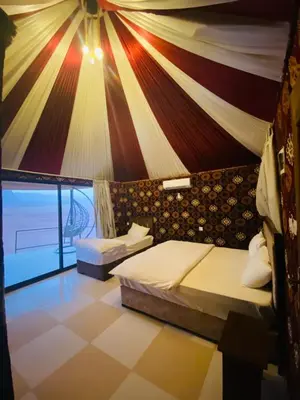 a room with two beds and a wall with a banner at LAVRA lUXURY CAMP in Wadi Rum